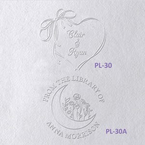 May include: Two embossed designs on white paper. The top design features a heart formed by a ribbon with the text Clair & Ryan and the code PL-30. The bottom design is a circular stamp with a crescent moon, flowers, and the text FROM THE LIBRARY OF ANNA MORRISON PL-30A.