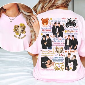 May include: A light pink t-shirt featuring a graphic design. The front of the shirt has a skull with horns and the text "HUNT THE VILLAIN". The back of the shirt has illustrations of two men, a motorcycle, and text.