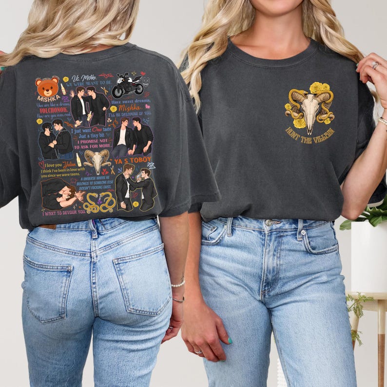 May include: Dark gray t-shirts with graphic designs. One shirt features a bear, text, and illustrations. The other shirt displays a skull with yellow roses and the text "HUNT THE VILLAIN".