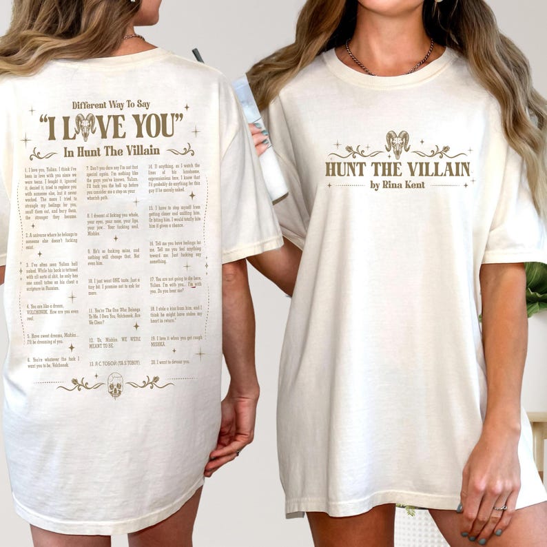 May include: Cream-colored t-shirt featuring the text "HUNT THE VILLAIN" and "by Rina Kent" in brown. The back of the shirt has a list of phrases under the title "Different Way To Say 'I LOVE YOU' In Hunt The Villain".