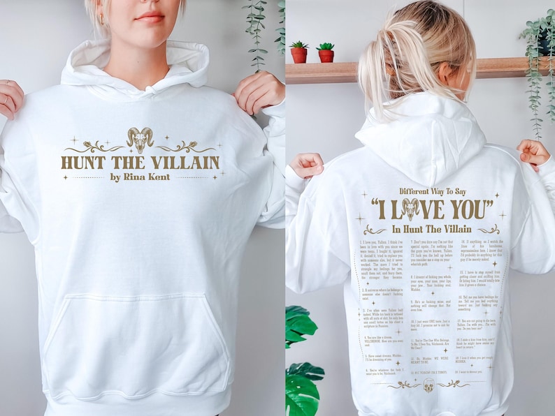 May include: A white hooded sweatshirt with the text "HUNT THE VILLAIN" and "by Rina Kent" in a gold color on the front. The back of the sweatshirt has the text "Different Way To Say 'I LOVE YOU' In Hunt The Villain".