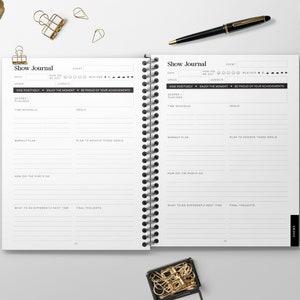 May include: An open, black and white journal with the title "Show Journal" printed on the cover. The journal has a spiral binding and is divided into sections for recording dates, events, scores, goals, and final thoughts.
