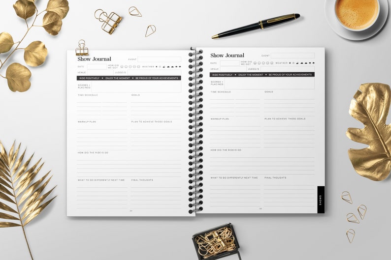 May include: An open, black and white journal with the title "Show Journal" printed on the cover. The journal has a spiral binding and is divided into sections for recording dates, events, scores, goals, and final thoughts.