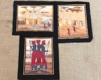 May include: Three framed pictures depicting scenes from African life. The top left picture shows a hut with a thatched roof. The top right picture shows a group of people walking. The bottom picture shows three people standing together.