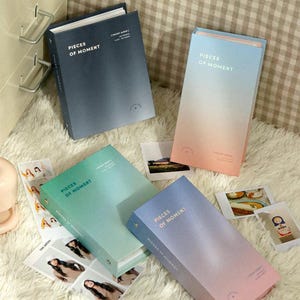Op de afbeelding: Vier fotoalbums met een verloopkleurendesign. De albums zijn getiteld "Pieces of Moment" en hebben een zakalbumontwerp. De albums zijn in blauw, groen, roze en lichtblauw.