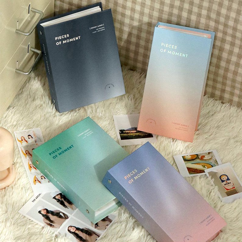 Op de afbeelding: Vier fotoalbums met een verloopkleurendesign. De albums zijn getiteld "Pieces of Moment" en hebben een zakalbumontwerp. De albums zijn in blauw, groen, roze en lichtblauw.