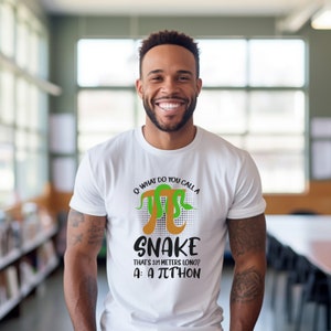 Może przedstawiać: Biała koszulka z graficznym wzorem przedstawiającym zielonego i pomarańczowego węża owiniętego wokół symbolu pi. Tekst brzmi: "P: Jak nazywasz węża o długości 3,14 metra? O: πthon."