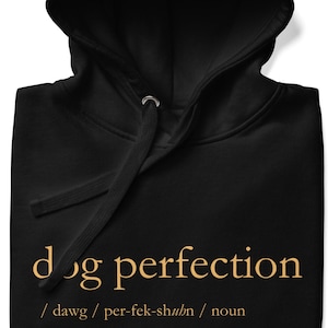 May include: Black hoodie with a gold graphic that says "dog perfection" and defines the word as "a perfect embodiment or example of the etiquette, physicality, and charm of a Canis familiaris."