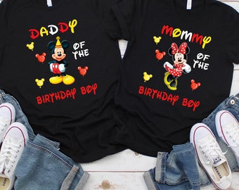 May include: Two black t-shirts featuring a Mickey Mouse and Minnie Mouse design. The shirts read "Daddy of the Birthday Boy" and "Mommy of the Birthday Boy".