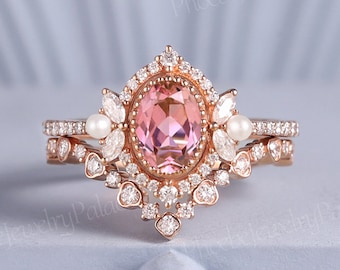 May include: A rose gold engagement ring set with a pink oval gemstone surrounded by smaller diamonds. The ring features a delicate floral design with pearl accents.