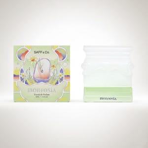 May include: A perfume bottle and box set. The box is light green with the text "SAFF & Co." and "MORFOSIA". The bottle is clear with a light green base. The set is on a white background.