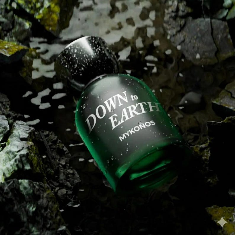 May include: A dark green perfume bottle with the text "DOWN to EARTH MYKONOS" in white. The bottle is partially covered in water droplets and sits among dark rocks and water.