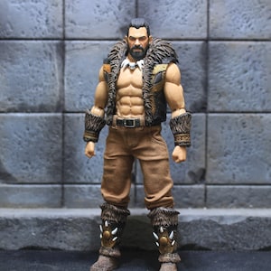 Può includere: Una action figure dettagliata di un uomo muscoloso con barba e capelli lunghi. Indossa un gilet di pelliccia marrone, pantaloni marroni e stivali di pelle marroni con accenti di pelliccia. Ha una collana con un ciondolo di osso.