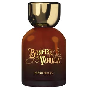 May include: A brown glass perfume bottle with a gold cap. The bottle has the words "Bonfire Vanilla" in gold script, with "Mykonos" below. The bottle has a rounded shape.