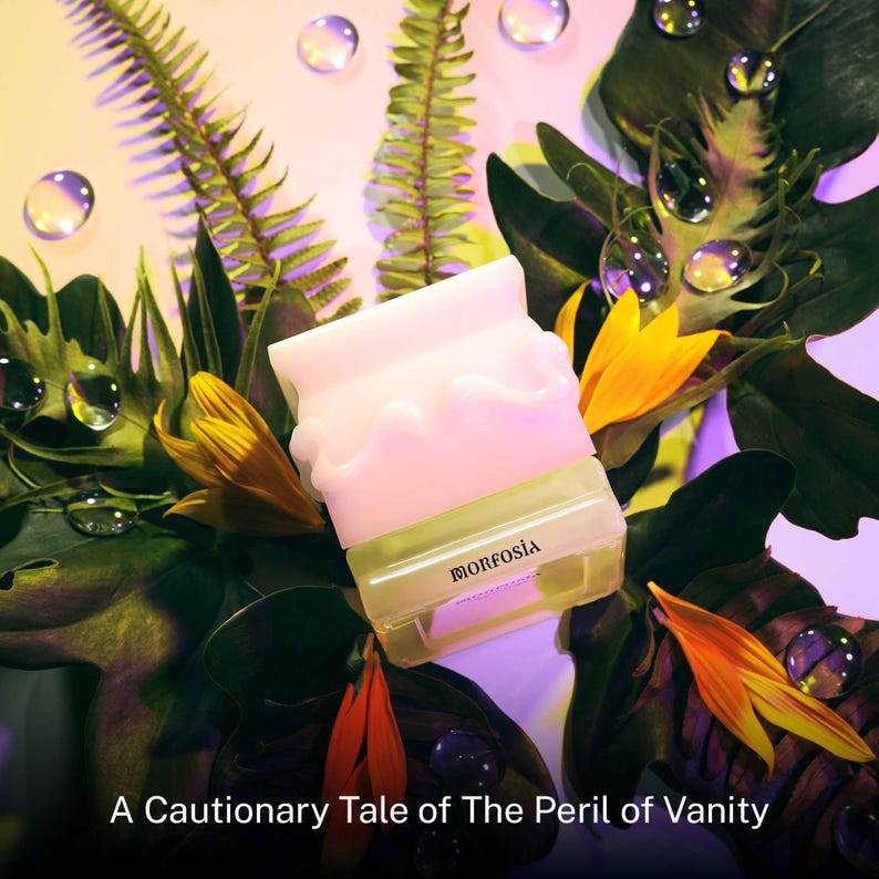 May include: A light pink and clear beauty product container with the word "MORFOSIA" printed on it, surrounded by green leaves, yellow flowers, and water droplets. The text "A Cautionary Tale of The Peril of Vanity" is at the bottom.