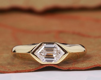 May include: A gold ring with a bezel setting featuring a clear, octagonal-shaped diamond.