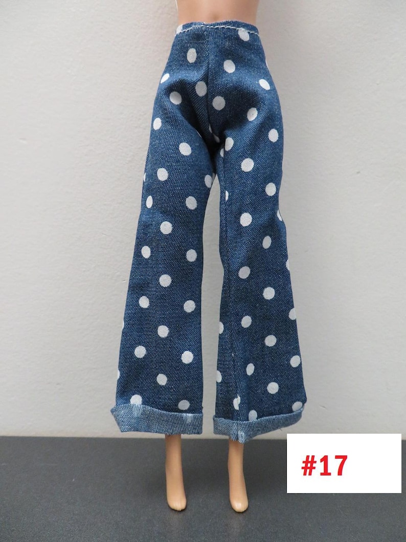 May include: Blue denim doll pants with white polka dots. The pants have a wide leg design and are cuffed at the bottom. The tag in the image reads #17.