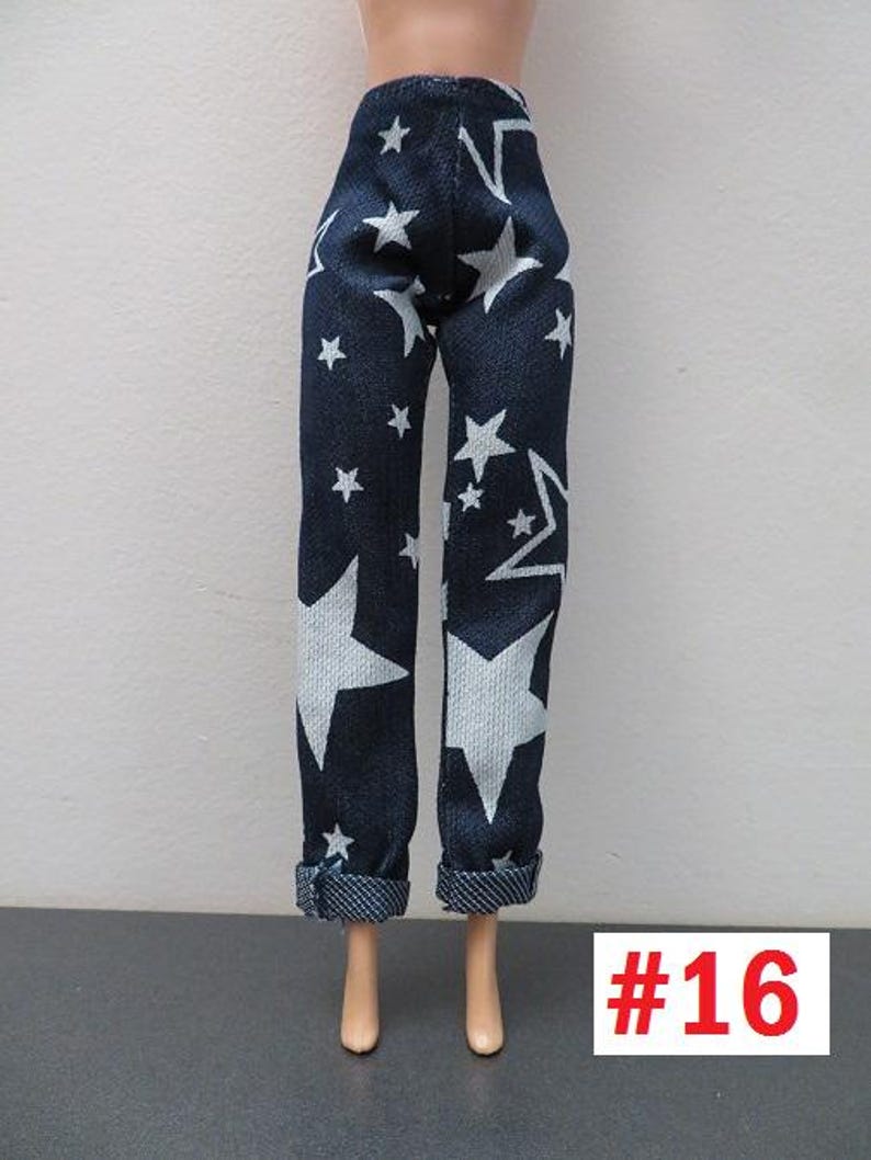 May include: Dark blue doll pants with a white star pattern. The pants have a cuffed hem and are displayed on a doll. The number "16" is in a red box in the lower right corner.