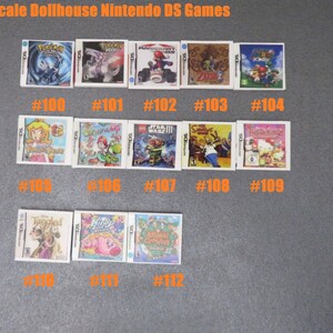 Peut inclure: Miniatures de jeux Nintendo DS pour maison de poup&eacute;e. Les jeux incluent des titres comme Pok&eacute;mon, Mario Kart et The Legend of Zelda. Chaque jeu est num&eacute;rot&eacute;, comme #100, #101 et #102. Le texte "1/6 Scale Dollhouse Nintendo DS Games" est en haut.