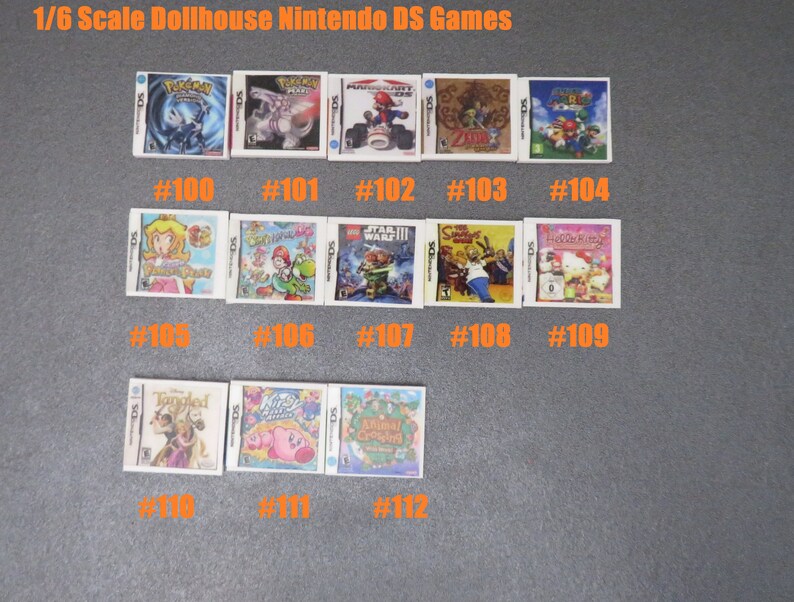Peut inclure: Miniatures de jeux Nintendo DS pour maison de poup&eacute;e. Les jeux incluent des titres comme Pok&eacute;mon, Mario Kart et The Legend of Zelda. Chaque jeu est num&eacute;rot&eacute;, comme #100, #101 et #102. Le texte "1/6 Scale Dollhouse Nintendo DS Games" est en haut.