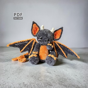 Bat Dragon Crochet Pattern finished spooky cute amigurumi plushie with oversized bat ears, wings, horns, and orange Halloween details