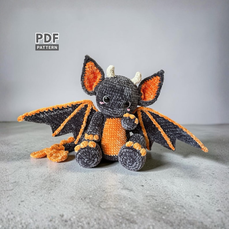 Bat Dragon Crochet Pattern finished spooky cute amigurumi plushie with oversized bat ears, wings, horns, and orange Halloween details