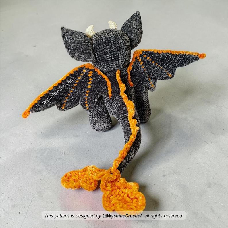 Halloween amigurumi dragon plushie with dramatic black and orange bat wings, long tail, leaf details, and cozy autumn charm