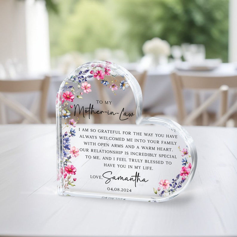 Puede incluir: Un pisapapeles de acr&iacute;lico transparente en forma de coraz&oacute;n con un dise&ntilde;o floral y un mensaje que dice: "A mi suegra Estoy tan agradecida por la forma en que siempre me has dado la bienvenida a tu familia con los brazos abiertos y un coraz&oacute;n c&aacute;lido. Nuestra relaci&oacute;n es incre&iacute;blemente especial para m&iacute;, y me siento realmente bendecida de tenerte en mi vida. Con amor. Samantha 04.08.2024"