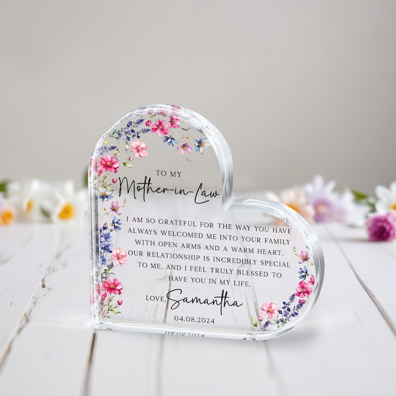 Puede incluir: Una placa de acr&iacute;lico en forma de coraz&oacute;n con un dise&ntilde;o floral y un mensaje para una suegra. El mensaje dice: "A mi suegra, Estoy tan agradecida por la forma en que siempre me has dado la bienvenida a tu familia con los brazos abiertos y un coraz&oacute;n c&aacute;lido. Nuestra relaci&oacute;n es incre&iacute;blemente especial para m&iacute;. Y me siento realmente bendecida de tenerte en mi vida. Con amor, Samantha 04.08.2024".