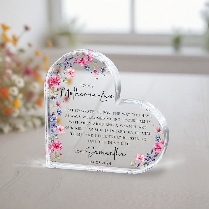 Puede incluir: Una placa acr&iacute;lica en forma de coraz&oacute;n con un dise&ntilde;o floral y un mensaje para una suegra. El mensaje dice: "A mi suegra Estoy tan agradecida por la forma en que siempre me has dado la bienvenida a tu familia con los brazos abiertos y un coraz&oacute;n c&aacute;lido. Nuestra relaci&oacute;n es incre&iacute;blemente especial para m&iacute;, y me siento realmente bendecida de tenerte en mi vida. Con amor, Samantha 04.08.2024"