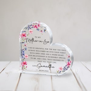 Puede incluir: Una placa de acr&iacute;lico en forma de coraz&oacute;n con un dise&ntilde;o floral y un mensaje para una suegra. El mensaje dice: "A mi suegra, Estoy tan agradecida por la forma en que siempre me has dado la bienvenida a tu familia con los brazos abiertos y un coraz&oacute;n c&aacute;lido. Nuestra relaci&oacute;n es incre&iacute;blemente especial para m&iacute;, y me siento realmente bendecida de tenerte en mi vida. Con amor, Samantha, 04.08.2024".