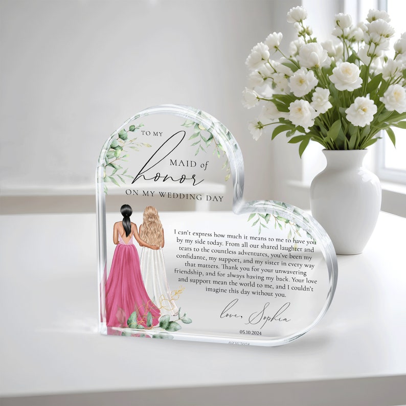 May include: A heart-shaped acrylic keepsake with a floral design and a message to a maid of honor. The message reads "To my Maid of Honor on my Wedding Day." The text continues with a heartfelt message of appreciation and love. The date "05.10.2024" is also included.