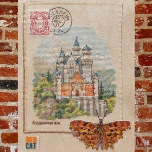 Pode incluir: Ponto cruz do Castelo de Neuschwanstein com uma borboleta e um selo postal. O castelo apresenta torres laranja, brancas e azuis. A borboleta tem asas laranja e castanhas. O fundo é um céu azul claro.