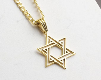 May include: A gold chain necklace with a gold Star of David pendant. The pendant is a double layered design with a hollow center.