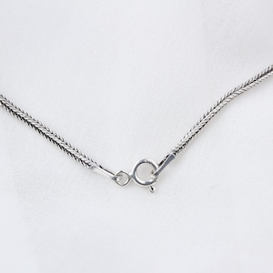 Op de afbeelding: Een zilveren ketting met een karabijn sluiting.