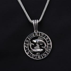 Op de afbeelding: Zilveren ketting met een ronde hanger met het sterrenbeeld Vissen, twee vissen en de astrologische tekens van de dierenriem.