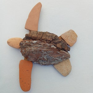 May include: A brown, bark-like piece of wood with a star shape made of smaller pieces of wood and terracotta colored stones.