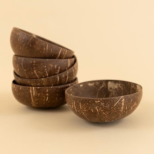 May include: Six brown coconut bowls with a natural, textured finish, stacked together. One bowl is separate, showing the interior. The bowls are dark brown with lighter brown streaks.