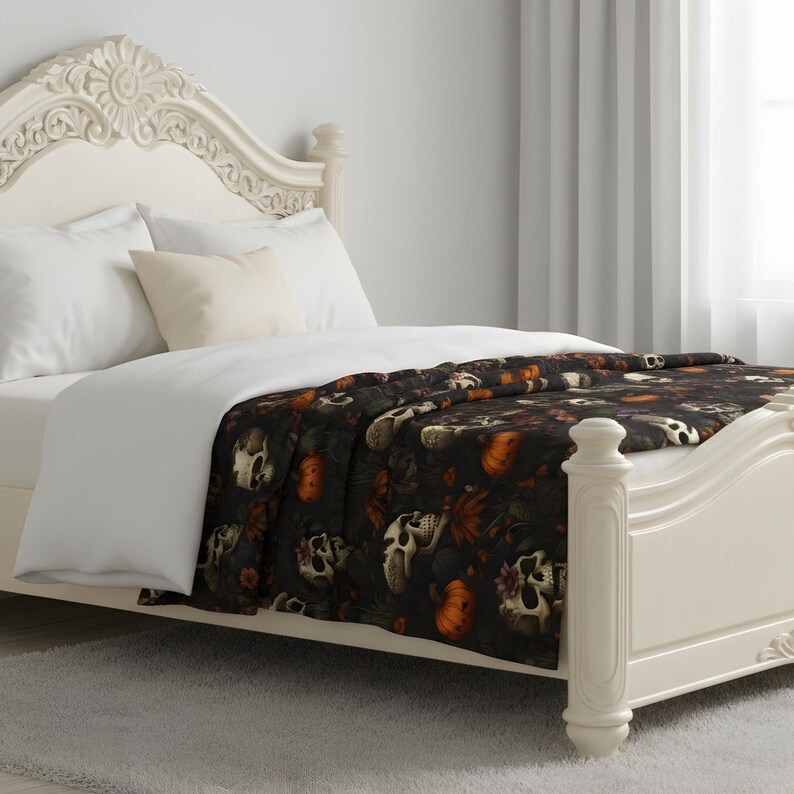 Dead Harvest skull blanket styled on a bed with soft Gothic autumn color and moody pattern.