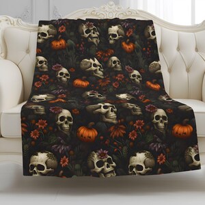 Dead Harvest Gothic throw blanket with skulls, pumpkins, and dark florals styled on a cream sofa