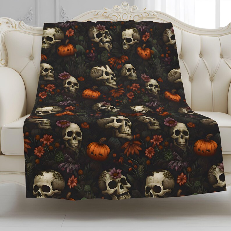 Dead Harvest Gothic throw blanket with skulls, pumpkins, and dark florals styled on a cream sofa