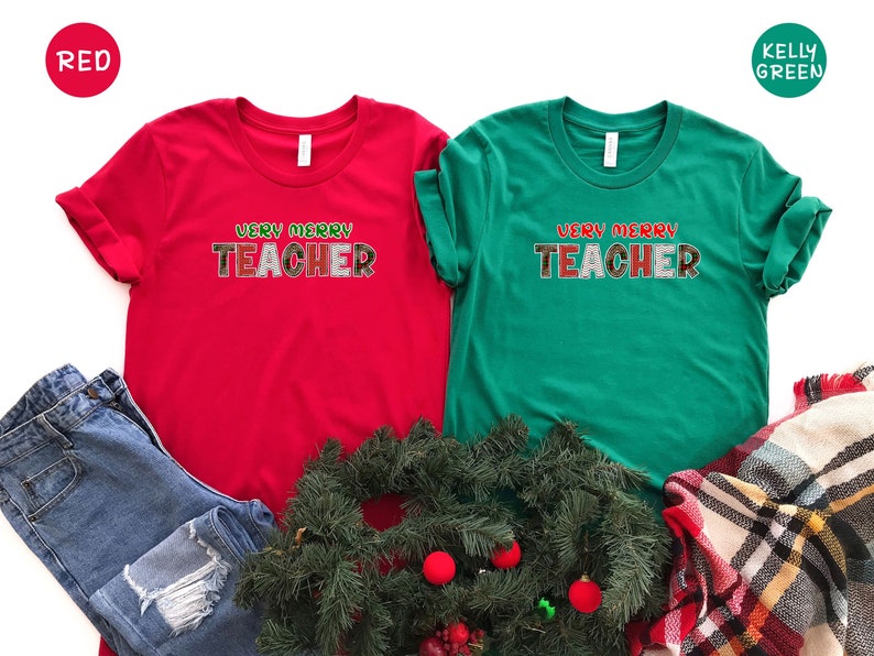 May include: Two Christmas themed t-shirts, one red and one green, with the text "Very Merry Teacher" in red and green letters.