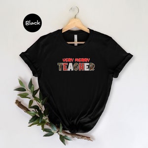May include: Black t-shirt with the text "Very Merry Teacher" in red and green plaid letters.