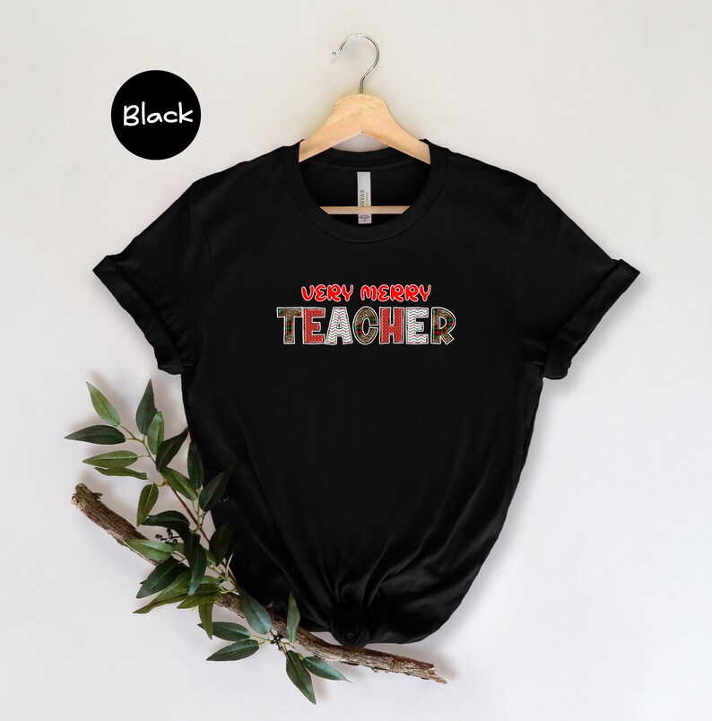 May include: Black t-shirt with the text "Very Merry Teacher" in red and green plaid letters.