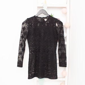 May include: Black lace long-sleeve dress with a geometric pattern.