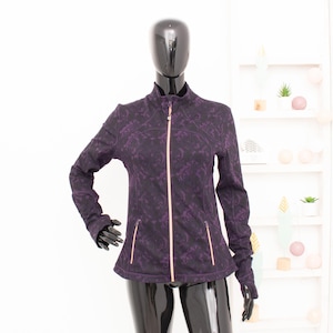 May include: A black and purple patterned zip-up jacket with a rose gold zipper.