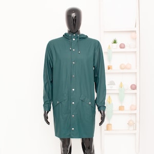 May include: A dark teal, hooded raincoat with a button-up front and two front pockets. The long coat is displayed on a black mannequin. The raincoat is a solid color and appears to be made of a waterproof material.