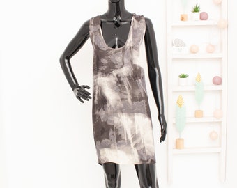 Peut inclure: Une robe sans manches avec un imprimé abstrait gris et blanc. La robe est sur un mannequin noir.