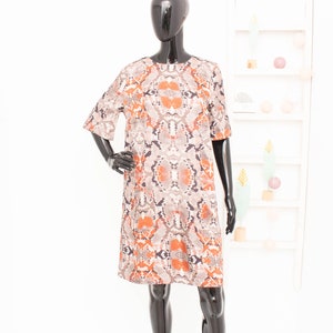 Può includere: Un abito a maniche corte con stampa effetto pelle di serpente in tonalità di marrone, arancione e nero.