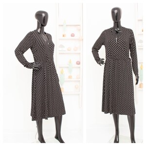 May include: A black and white polka dot dress with a V-neckline and long sleeves.